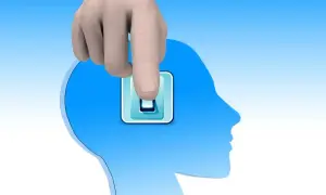 Dłoń naciska włącznik na tle głowy, symbolizując wyłączenie myśli i ulgę od zmęczenia psychicznego.