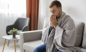 Mężczyzna okryty kocem, z chusteczką przy nosie, może sugerować objawy choroby, ale czasem to tylko próba zwrócenia na siebie uwagi, jak w przypadku zespołu Munchausena.