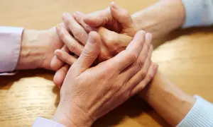 Dłonie splatają się w geście wsparcia, symbolizując pomoc i zrozumienie w walce z wypaleniem zawodowym. Jak sobie radzić, gdy czujesz się wyczerpany?
