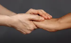 Dwie dłonie splatają się, symbolizując wsparcie i nadzieję dla psychiki mężczyzny po rozwodzie.