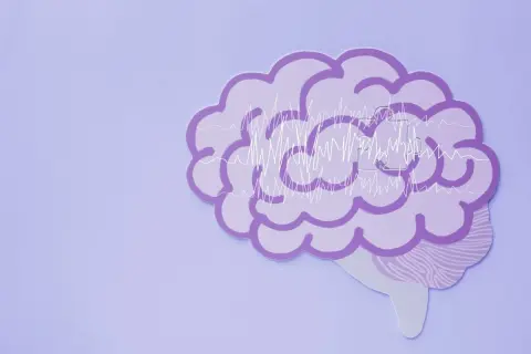 Fioletowy mózg z wykresami fal mózgowych, symbolizujący zdrowie psychiczne definicja.