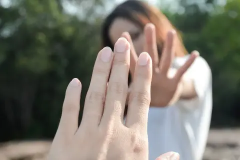 Dwie dłonie, jedna bliżej, druga dalej, symbolizują niespełnioną miłość i dystans.