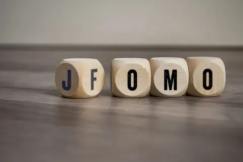 Drewniane kostki z literami J, F, O, M, O. Czy to FOMO? Strach przed tym, że coś nas omija.