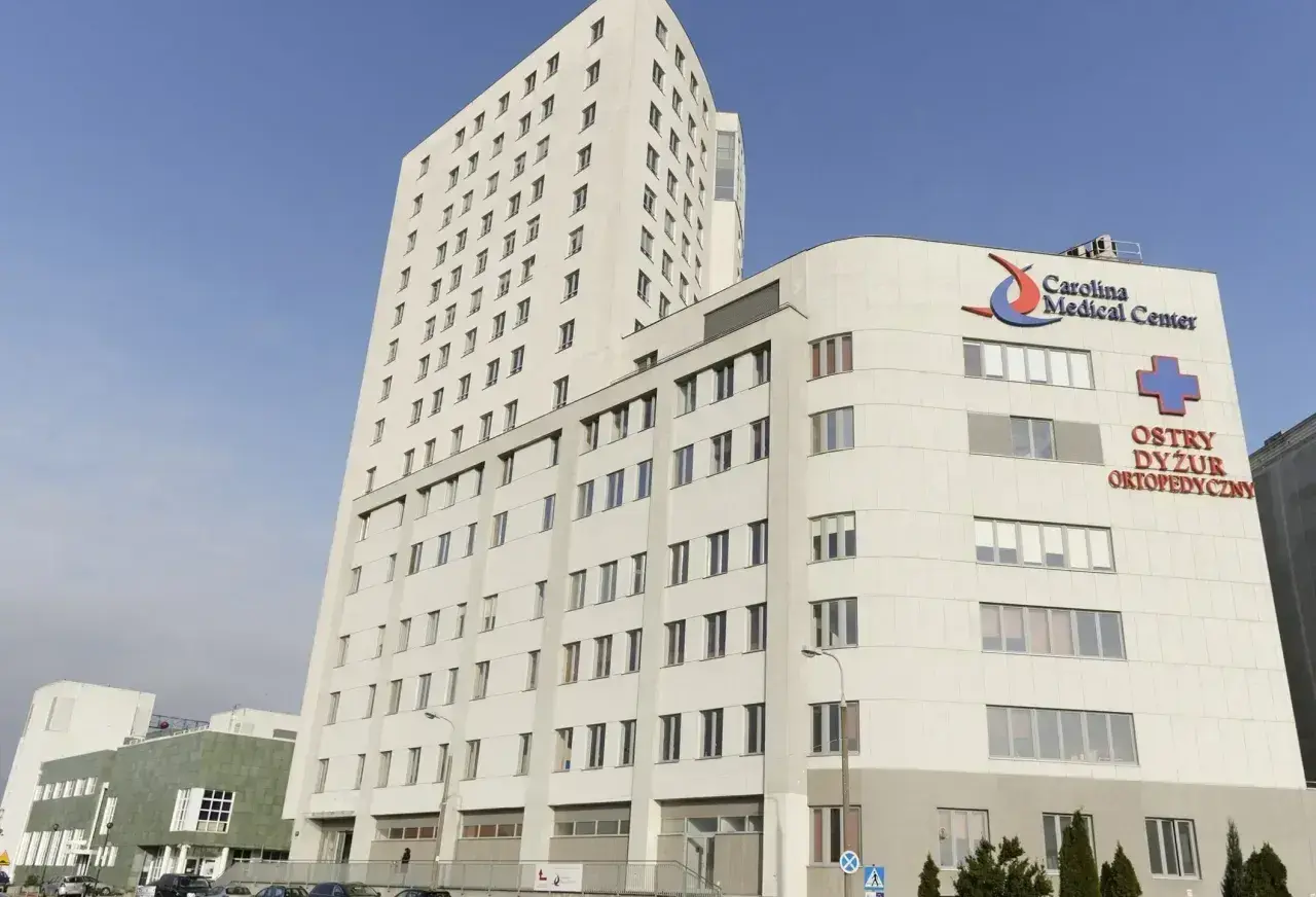 Nowoczesny budynek Carolina Medical Center w Warszawie z logo i napisem "Ostry Dyżur Ortopedyczny".