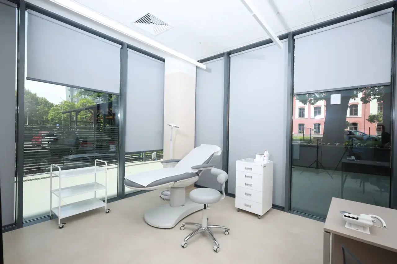Gabinet dermatologiczny z fotelem zabiegowym, szafką i wózkiem.