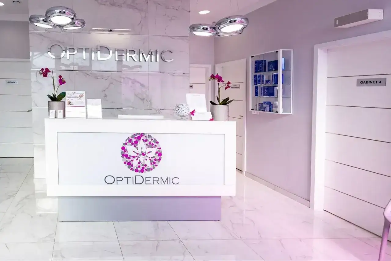 Nowoczesne wnętrze kliniki OptiDermic z recepcją, logo i gabinetami.