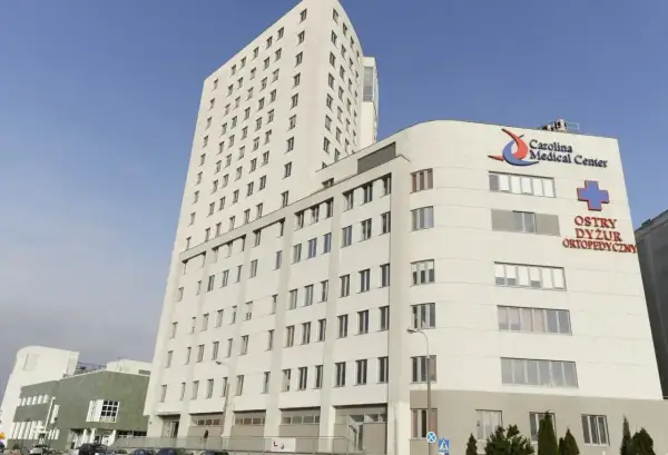 Nowoczesny budynek Carolina Medical Center w Warszawie z logo i napisem "Ostry Dyżur Ortopedyczny".