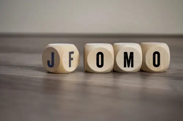 Drewniane kostki z literami J, F, O, M, O. Czy to FOMO? Strach przed tym, że coś nas omija.